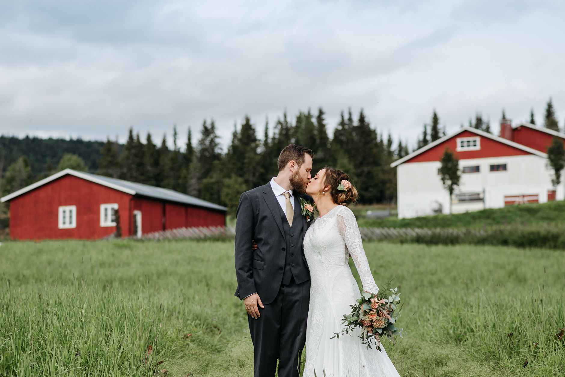 Newlyweds kissing near a rustic Kansas barn