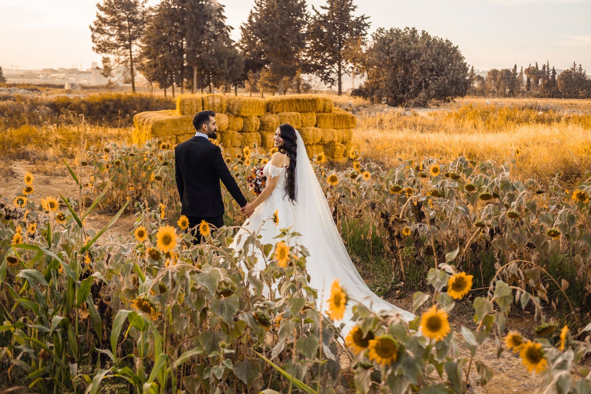 A couple holding hands in a Kansas sunflower field